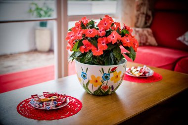 Bir vazo çiçekli bir oturma odası ve şenlik için dekore edilmiş bir masa.