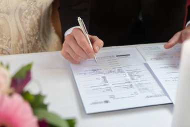 Gelin ve damat evlilik belgesini veya evlilik belgesini imzalıyorlar.