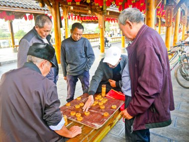 Çin, LeShan, 01.01.2025 yaşlılar eski şehirde sokak boyunca Çin satrancı oynuyorlar.