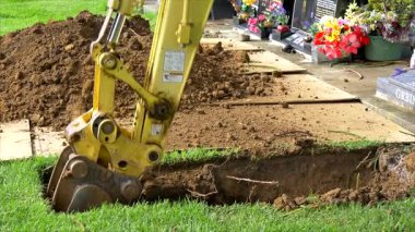 Auckland, Yeni Zelanda, 01.01.2025, Mezarlığı ve mezar taşını cenaze için hazırlamak üzere ağır makineler ve kazıcı yerleştirildi. 