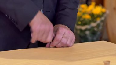 Cenaze töreninde bir tabutun kapağını veya tabutun kapağını vidayı çevirerek kapatmak.