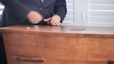 Cenaze töreninde bir tabutun kapağını veya tabutun kapağını vidayı çevirerek kapatmak.