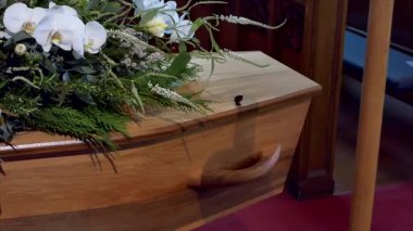 Aile, cenaze töreninden sonra tabutun içine çiçek yaprakları yerleştiriyor.