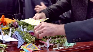 Aile, cenaze töreninden sonra tabutun içine çiçek yaprakları yerleştiriyor.