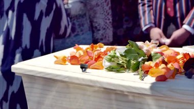 Aile, cenaze töreninden sonra tabutun içine çiçek yaprakları yerleştiriyor.