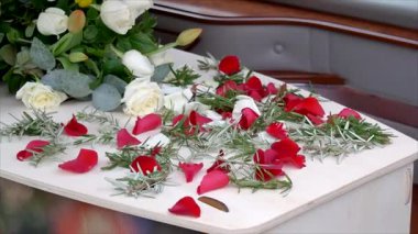 Aile, cenaze töreninden sonra tabutun içine çiçek yaprakları yerleştiriyor.