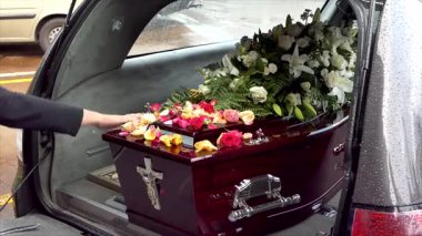 Aile, cenaze töreninden sonra tabutun içine çiçek yaprakları yerleştiriyor.