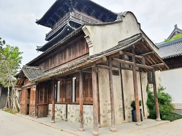 Geleneksel Çin ahşap binası, karmaşık kafes camları, katmanlı çatı tasarımı ve kırsal sütunları sessiz bir yürüyüş yolu boyunca duruyor. 