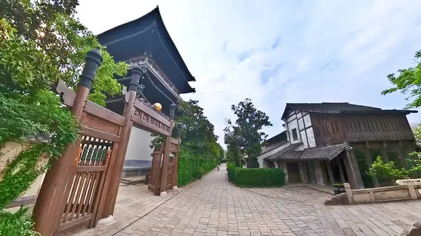 Geleneksel Çin ahşap binası, karmaşık kafes camları, katmanlı çatı tasarımı ve kırsal sütunları sessiz bir yürüyüş yolu boyunca duruyor. 