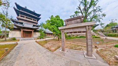 Eski çadırlar, taştan bir heykel, yemyeşil yemyeşil ve ağaçların altında huzurlu yürüyüş yolları olan sakin geleneksel bir Çin bahçesi. 