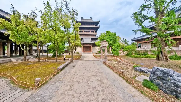 Eski çadırlar, taştan bir heykel, yemyeşil yemyeşil ve ağaçların altında huzurlu yürüyüş yolları olan sakin geleneksel bir Çin bahçesi. 