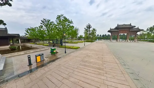 Geleneksel ahşap binalarla çevrili ve yemyeşil ağaçlarla gölgelenmiş sakin bir ara sokakta taş bir patika esiyor. 