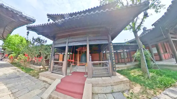 Geleneksel çok katmanlı Çin pagodası verimli yeşilliklerin arasında zarif bir şekilde duruyor. Büyük ahşap girişine doğru taş adımlar atıyor.. 