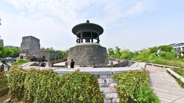 Çevresi yeşillik ve yürüyüş yollarıyla çevrili antik bir taş tapınak, ziyaretçiler tarihi ve sakin açık hava ortamını keşfediyorlar.. 