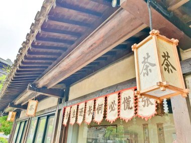 Bereketli yeşillik ve geleneksel mimariyle çevrili, dağ oymalarıyla dekoratif bir duvarın yanında huzurlu bir taş yol uzanıyor. 