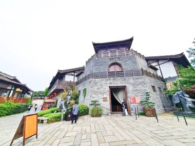 Ahşap kapılar, fenerler, bekçi kuleleri ve çevresindeki yeşilliklerle dolu kadim taş kale kapısı, parlak bulutlu bir gökyüzü altında.. 