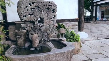 Bir düğün yeri beyaz sütunlar, turuncu ve beyaz çiçekler ve büyük, dekoratif bir haçla süslenir. 