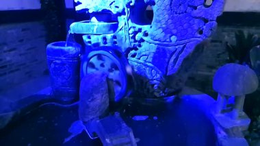 Bir düğün yeri beyaz sütunlar, turuncu ve beyaz çiçekler ve büyük, dekoratif bir haçla süslenir. 