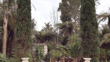 Bir düğün yeri beyaz sütunlar, turuncu ve beyaz çiçekler ve büyük, dekoratif bir haçla süslenir. 