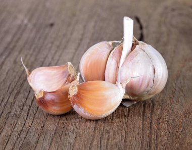 Bütün organik sarımsak ve ahşap arka planda karanfil.