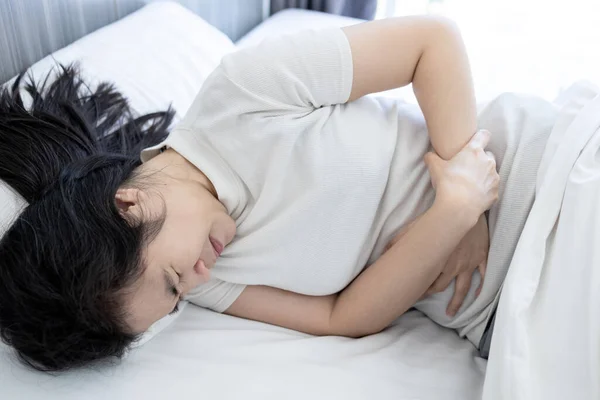 患有腹部疼痛 躺在床上 消化性溃疡 胃肠道疾病 胃溃疡 保健的亚洲妇女 — 图库照片