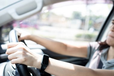 Cilt bakımını, kremi ya da losyonu güneş yanığını, güneş kremini ve güneş kremini önlemek için kullanırız. Güneş ışığı kollarda parlar ve kadın eli boş gezerken araba kullanır.