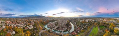 İsviçre 'nin başkenti Bern' in üzerinde renkli bir alacakaranlık romantik gökyüzü ile günbatımını geniş bir alana yaymak. Aare Nehri üzerindeki Panorama Manzarası Sonbaharda İsviçre 'nin tarihi şehir simgesi.