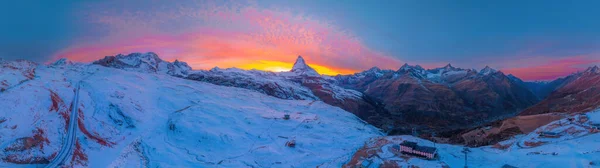 İsviçre 'de Matterhorn Dağı' nın muhteşem renkli alacakaranlık romantik gökyüzü manzarası. İsviçre Alplerindeki Zermatt kayak merkezinin gündoğumu ya da gün batımının geniş bir şekilde kurulması.