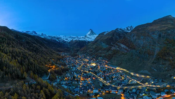Sonbaharda İsviçre 'nin Canton Valais şehrinde Zermatt şehrinin ünlü kayak merkezi ve şafak vakti ikonik Matterhorn zirvesinin en üst manzarası. En popüler güzel manzara gezisi merkezi..