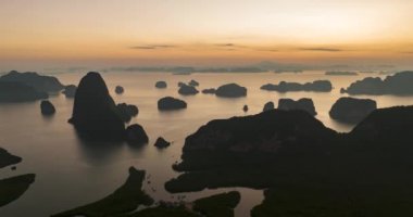 Phang Nga Körfezi 'nin havadan görünüşü, sabah vakti dağlarla birlikte Tayland, Krabi' de. İnanılmaz kızıl gökyüzünün dramatik deniz manzarası büyülü bir anda. Şahane doğal Drone körfezin üzerinde zaman aşımı yaşıyor..