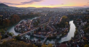 İsviçre 'nin başkenti Bern' in üzerinde renkli bir alacakaranlık romantik gökyüzü ile günbatımını geniş bir alana yaymak. Sonbaharda Aare Nehri üzerinde uçan İHA İsviçre tarihi şehir simgesi.