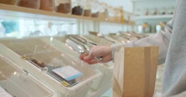 Yakından çekilen adam sıfır atık atölyesinde yeniden kullanılabilir kağıt torbayı biyolojik organik ürünlerle dolduruyor. Erkek, plastik marketten yiyecek alıyor. Çevre dostu iş girişimi yeşil piyasaya çıktı. Yeniden Kullan Geri Dönüşümü Azalt.