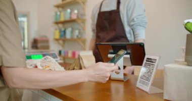 Müşteri, akıllı telefon tarama dükkanı QR kodunu kullanarak sıfır atık plastik markete ücretsiz ödeme yapıyor. Nakitsiz ödeme yaşam tarzı. Küçük işletmeler iklim değişikliğini azaltmak için yeşil başlangıç yaptı.