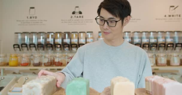 人类在零废品商店购买生态生物有机产品 亚洲男性在塑料免税店里拿着一块生态手工肥皂 天然化妆品护肤可持续生活方式 — 图库视频影像