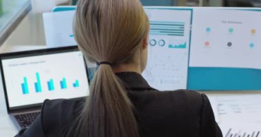 İş kadını girişimci, başarı planı stratejisi hakkında veri analizi yapıyor. Yetenekli kadın proje çalışması raporları bilgisayar ekranı ve evrak işlerinde istatistikleri analiz eder. Arka plan görünümü.