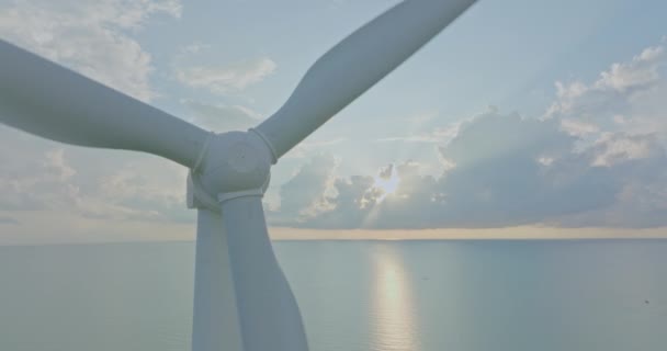 空中ビュー青空とエネルギー生産のための風力タービンを閉じます 風力発電所の上空をドローンが飛行し 持続可能な開発のためのクリーンな再生可能エネルギーを生み出す 緑の生態系世界 — ストック動画