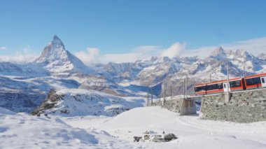 Güneşli bir kış gününde Zermatt 'ta, Matterhorn Dağı' nın zirvesine çıkan Gornergrat Bahn tren yolunun 4K Static Shot 'u. İsviçre Alpleri ve İsviçre seyahati.