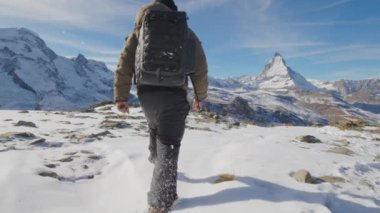 Asyalı turist, fotoğrafçı, sırt çantalı dağcı ünlü Matterhorn arka planına sahip kar dağına tırmanıyor. İsviçre seyahati Popüler turizm merkezleriyle dünyayı dolaşmak.