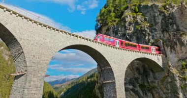 Buzul ve Bernina ekspres İsviçre Alpleri yaz mevsimi manzaralı Landwasser Viyaduct dünya mirası manzarası. Hava aracı Filisur, İsviçre 'deki ünlü dağdan geçen kırmızı treni vurdu..