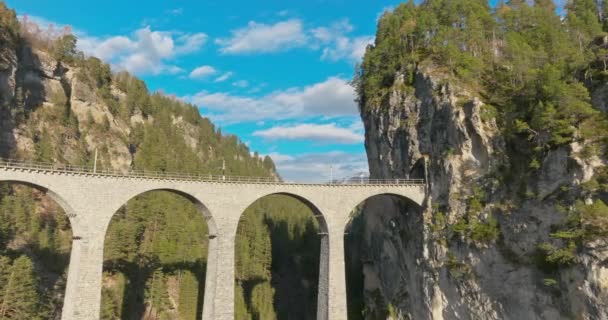 空中ドローンビューランドワッサーヴィアダクト世界遺産観光 スイスアルプスの豪華な氷河急行列車で秋の夏の風景 スイスのパノラマ風光明媚な鉄道景観観光 — ストック動画