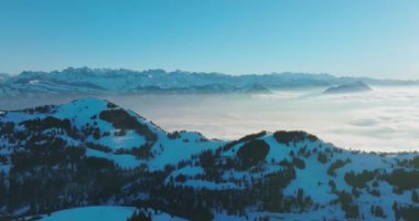 Hava aracı Rigi Dağı (Rigi Kulm) ve İsviçre 'nin altındaki Lucerne Gölü' nün zirvesinde bulutların üzerinde uçar. İnanılmaz kar ve sis İsviçre alp dağlarının zirvelerini ve kış manzarasını kapladı.