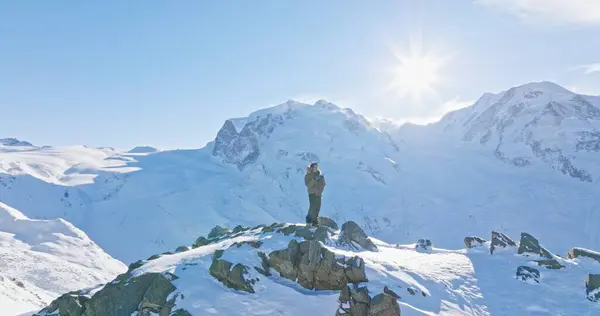 Ünlü Gornergrat rasathanesinin tepesinde duran Asyalı genç adamın panoramik manzarası ikonik ünlü Matterhorn gün batımı arka planıyla uzaktan kumandayla çalışıyor. İsviçre Alpleri, İsviçre.