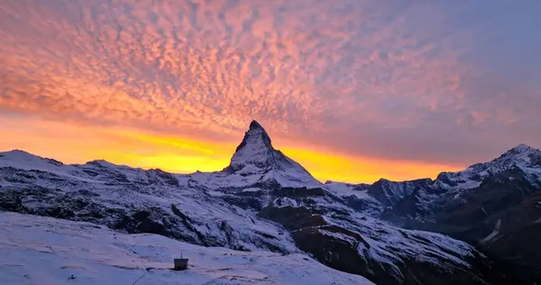 İsviçre 'deki muhteşem renkli alacakaranlık romantik gökyüzü ile ünlü Matterhorn Dağı' nın güzel manzarası. İsviçre Alpleri 'ndeki ikonik Zermatt kayak merkezinin sabah ya da gün batımında harika bir hava manzarası kurulması.