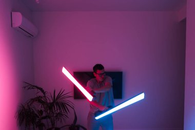 Evde öncü neon lazeri olan orta yaşlı bir adam, samuray ya da Jedi. Yüksek kalite fotoğraf