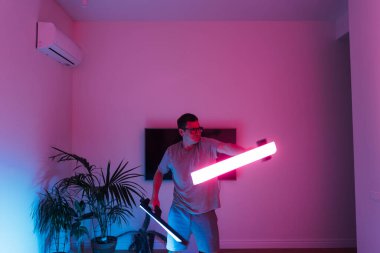 Evde öncü neon lazeri olan orta yaşlı bir adam, samuray ya da Jedi. Yüksek kalite fotoğraf