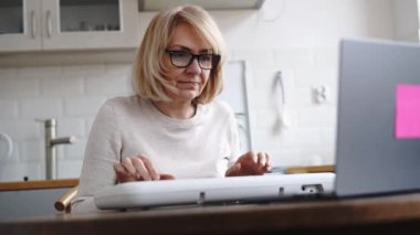 Olgun bir kadın piyano öğrenmek için online ders alıyor. Son sınıflar için E-öğrenme hobisi. Yüksek kalite 4k görüntü