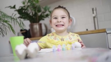 Ev mutfağında paskalya yumurtası boyayan okul çağındaki çocuk. Paskalya bahar gelenekleri. Ağır çekim. Yüksek kalite 4k görüntü