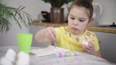 Ev mutfağında paskalya yumurtası boyayan okul çağındaki çocuk. Paskalya bahar gelenekleri. Ağır çekim. Yüksek kalite 4k görüntü