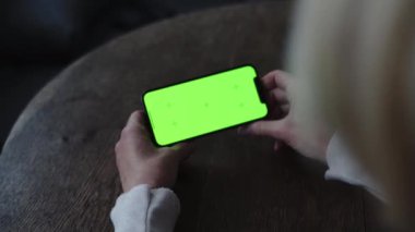 Akıllı telefon yeşil ekranlı olgun kadın elleri. Yüksek kalite 4k görüntü