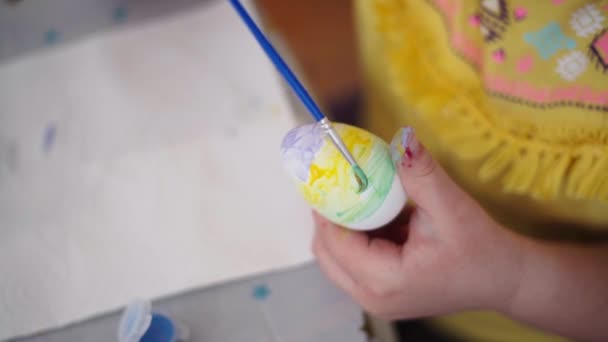 就学前の年齢の女の子は自宅のキッチンでイースターエッグを描いています イースターの春の伝統 スローモーション 高品質4K映像 — ストック動画